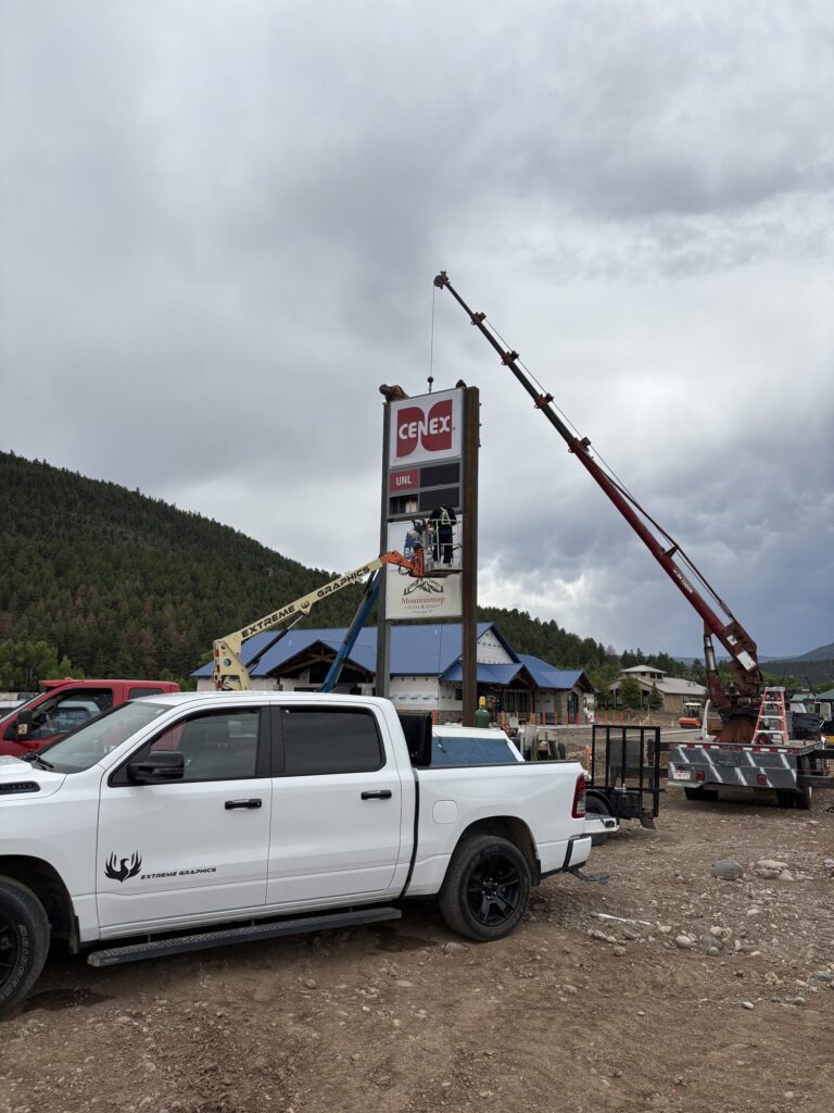 Extreme Graphics crew installing a Cenex and Mountaintop Gifts & Gear pylon sign in South Fork, CO with a crane and boom lift