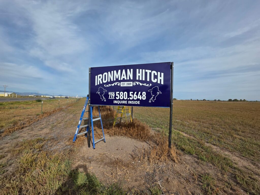 Ironman Hitch roadside post-and-panel sign along the highway