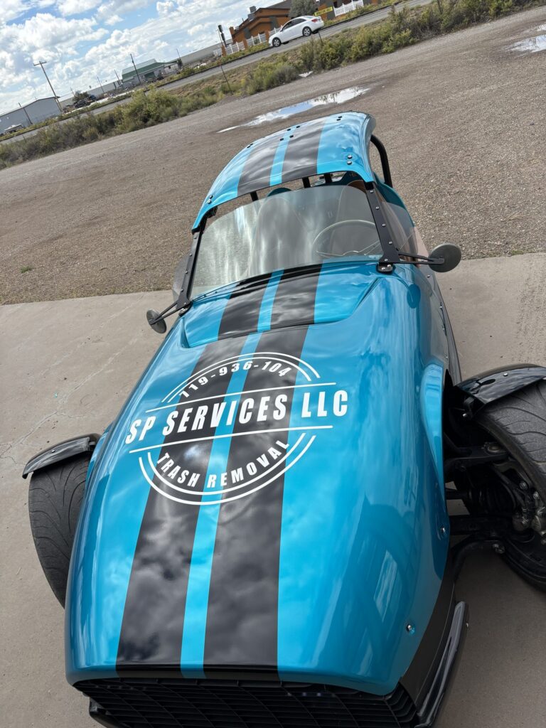 SP Services LLC logo and racing stripes on a blue roadster hood