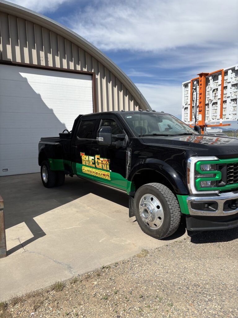True Grit Excavating graphics and green accents on a Ford F-450 dually